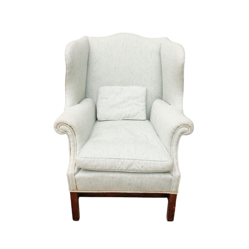 939 - A George III style mahogany wing armchair - light blue upholstery with a loose cushion seat, on squa... 