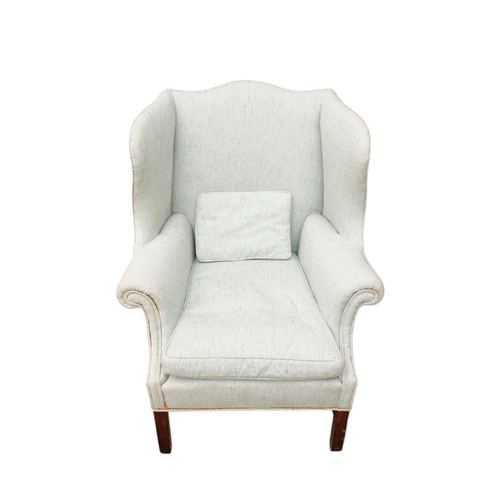 939 - A George III style mahogany wing armchair - light blue upholstery with a loose cushion seat, on squa... 