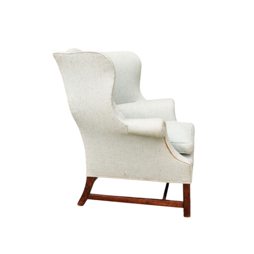 939 - A George III style mahogany wing armchair - light blue upholstery with a loose cushion seat, on squa... 