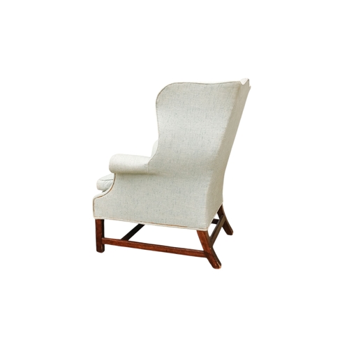 939 - A George III style mahogany wing armchair - light blue upholstery with a loose cushion seat, on squa... 