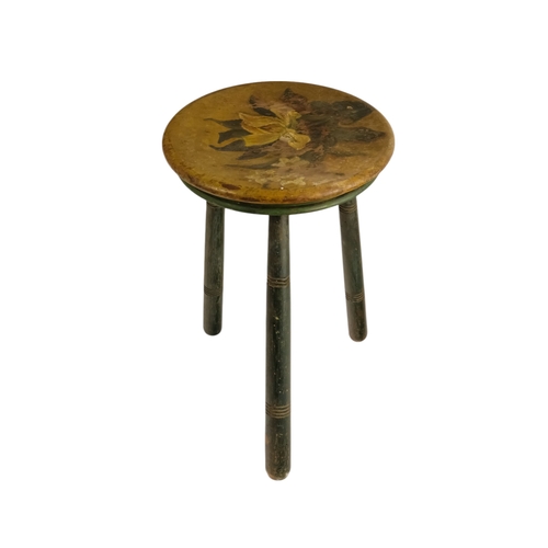 943 - A 19th century cricket stool - the circular seat painted with an iris, raised on three turned legs, ... 