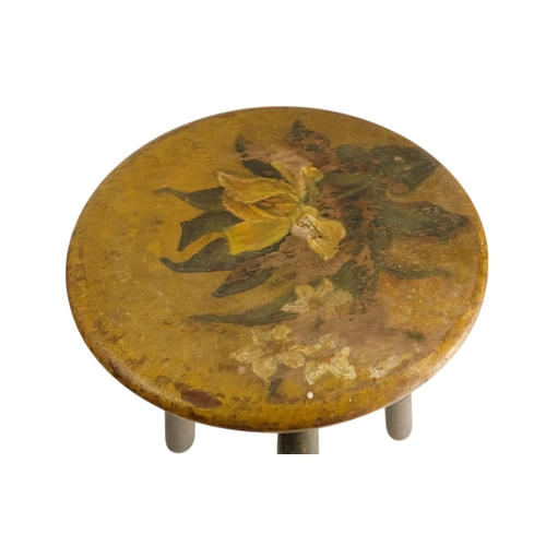 943 - A 19th century cricket stool - the circular seat painted with an iris, raised on three turned legs, ... 