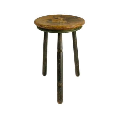 943 - A 19th century cricket stool - the circular seat painted with an iris, raised on three turned legs, ... 