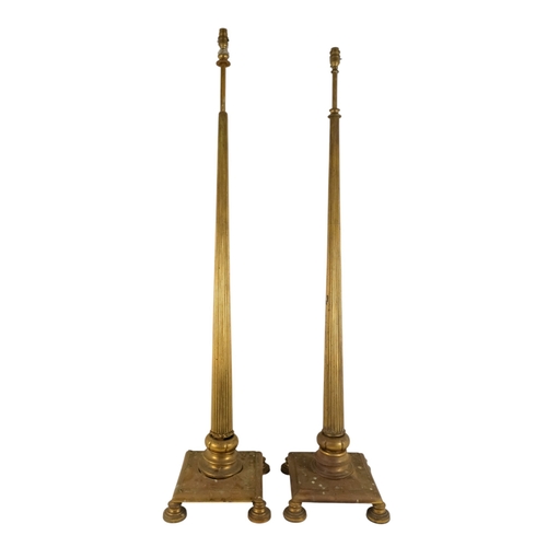 18 - A pair of brass adjustable standard lamps - with reeded columns and square bases on bun feet. (2)