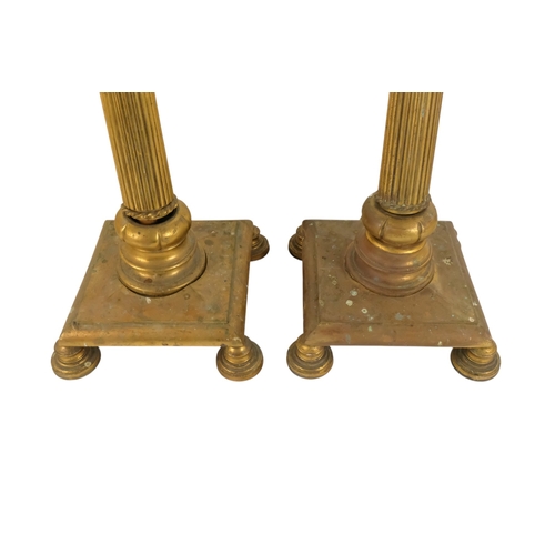 18 - A pair of brass adjustable standard lamps - with reeded columns and square bases on bun feet. (2)
