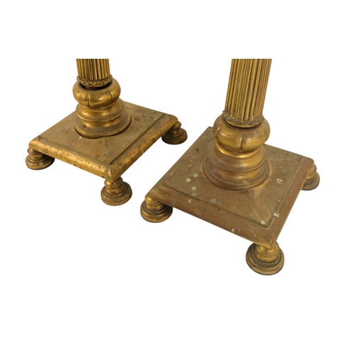 18 - A pair of brass adjustable standard lamps - with reeded columns and square bases on bun feet. (2)