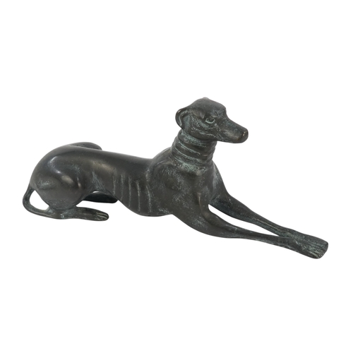 24 - An Art Deco style bronze dog - modelled as a greyhound in a recumbent pose, 26cm wide.