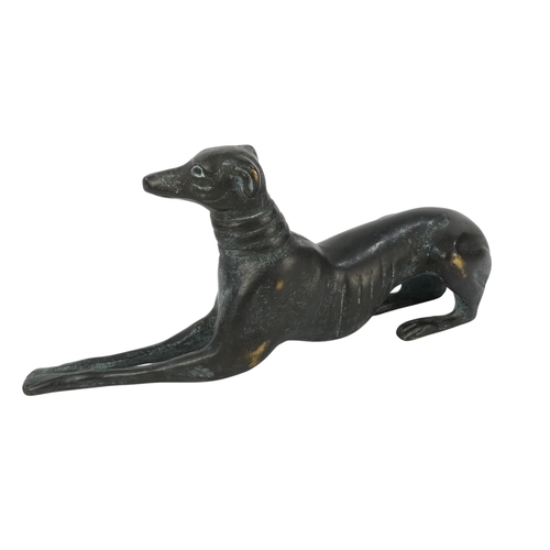 24 - An Art Deco style bronze dog - modelled as a greyhound in a recumbent pose, 26cm wide.