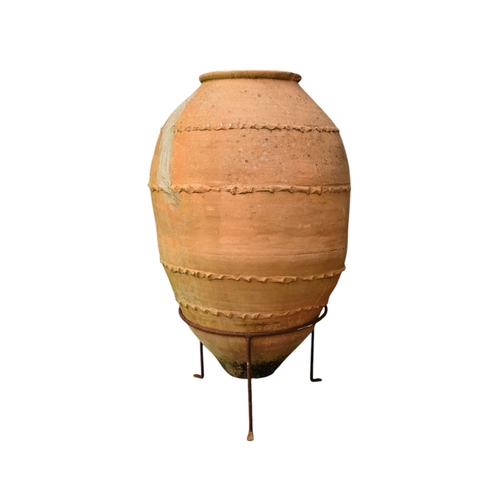 36 - A vintage terracotta olive jar - of classical form with a ribbed girdle, on a steel stand 53 x 90cm.
