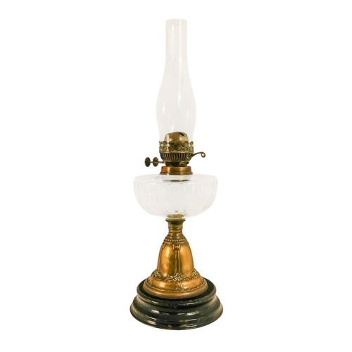 40 - A late Victorian oil lamp - with a flash-cut clear glass reservoir on a repousse brass support and c... 