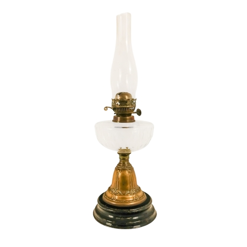 40 - A late Victorian oil lamp - with a flash-cut clear glass reservoir on a repousse brass support and c... 