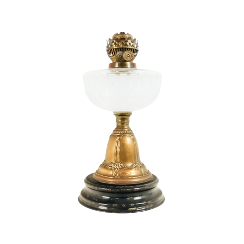 40 - A late Victorian oil lamp - with a flash-cut clear glass reservoir on a repousse brass support and c... 