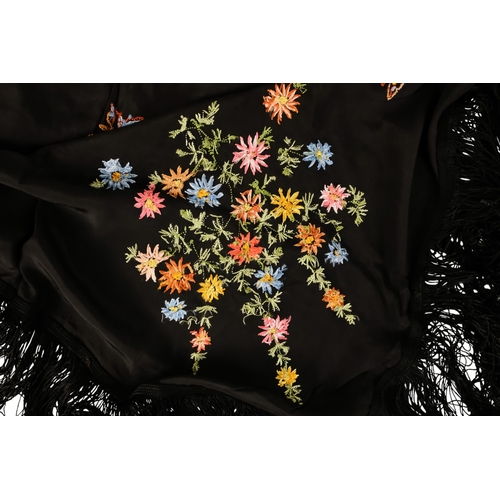 45 - An early 20th century black piano shawl - embroidered with flowers with a long fringe, together with... 