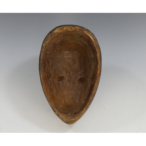 117 - An African hardwood mask - with a red forehead and white cheeks and jaw, 27cm high.