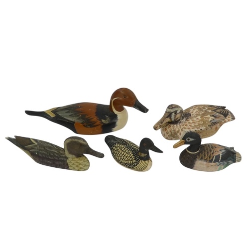 101 - A 20th century polychrome painted duck - 30cm wide, together with four other similar smaller example... 