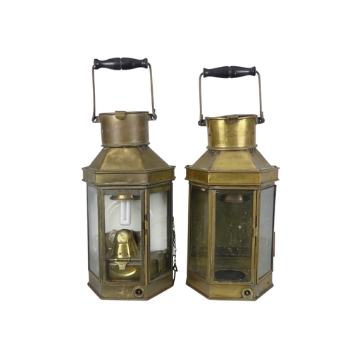 106 - A pair of brass ships lamps - of faceted form with flat backs, 41cm high.