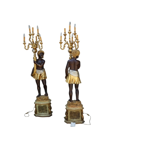 118 - A pair of Blackamoor lamps - gilded and polychrome painted, the figures holding multi-lamp torches, ... 