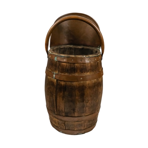 69 - A staved barrel/bucket with copper bindings, handles and lip - diameter 23cm, height 54cm.