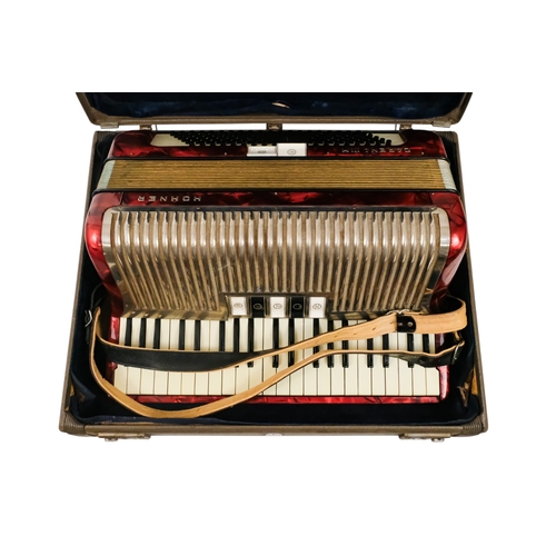 74 - A Hohner piano accordion - Carena IIIM, with a red marbled case and a grey carry case.