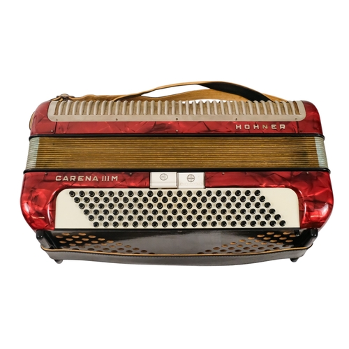 74 - A Hohner piano accordion - Carena IIIM, with a red marbled case and a grey carry case.