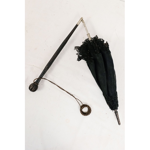 141 - An early 20th century parasol - with an oriental white metal handle profusely decorated with foliage... 