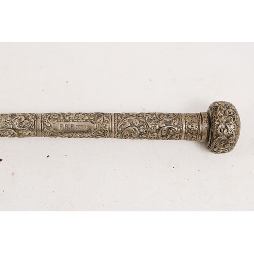 141 - An early 20th century parasol - with an oriental white metal handle profusely decorated with foliage... 