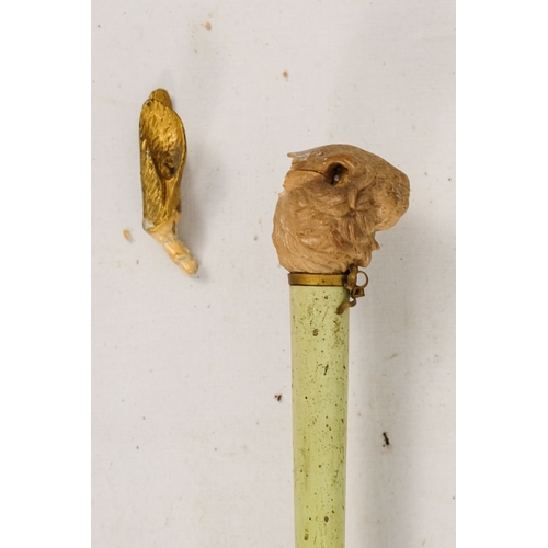 142 - An early 20th century white silk parasol - the green painted handle terminating in a carved rabbits ... 