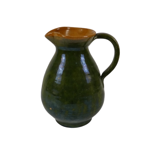 203 - A Biot Pottery style jug - with a green iridescent glaze, 21cm high.