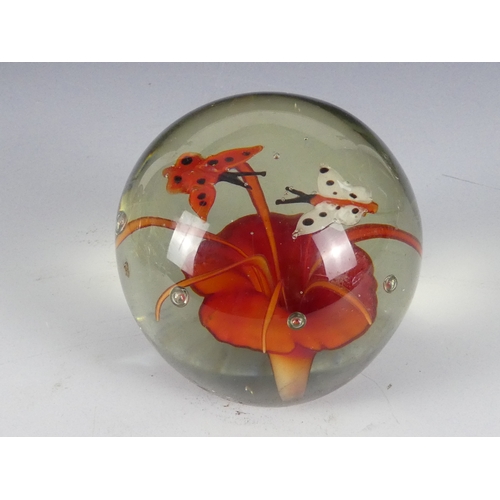 205 - A Wedgwood glass paperweight - set with an amber flower, 7cm diameter, together with four other simi... 