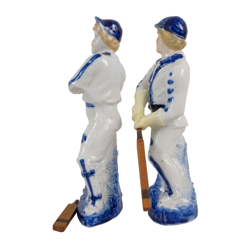 216 - A pair of early 20th century cricketing figures - each in a batting pose, 19cm high. (2)