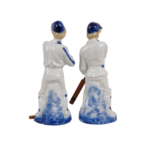 216 - A pair of early 20th century cricketing figures - each in a batting pose, 19cm high. (2)
