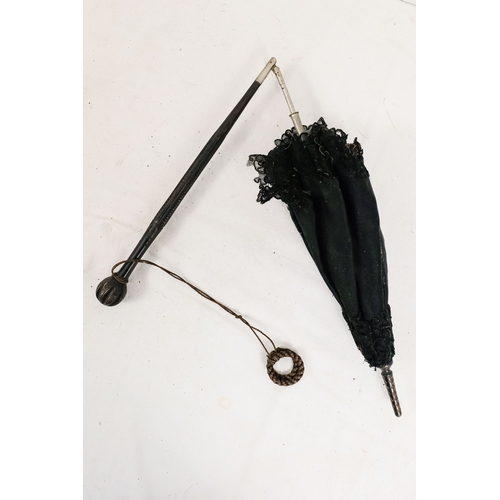 141 - An early 20th century parasol - with an oriental white metal handle profusely decorated with foliage... 