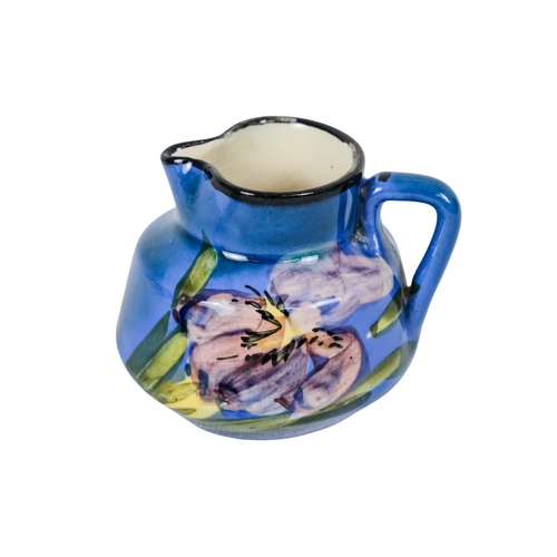 206 - A tubeline vase in the manner of Moorcroft - decorated with a leaf and flower on a pale blue ground,... 