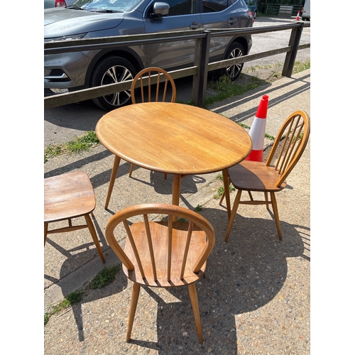 114 - Solid wood round ercol table and four matching chairs.