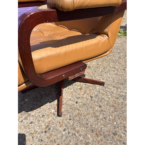 115 - 1970s swivel armchair with tan vinyl upholstery, wooden frame, and padded armrests.
