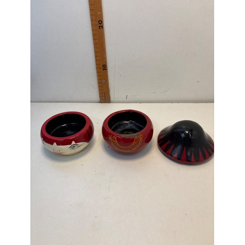19 - Painted japanese wooden lidded container featuring a figure-like design in red, black, and white wit... 