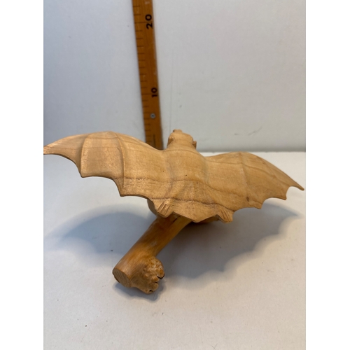 31 - Hand-carved driftwood sculpture of a bat on a stand.