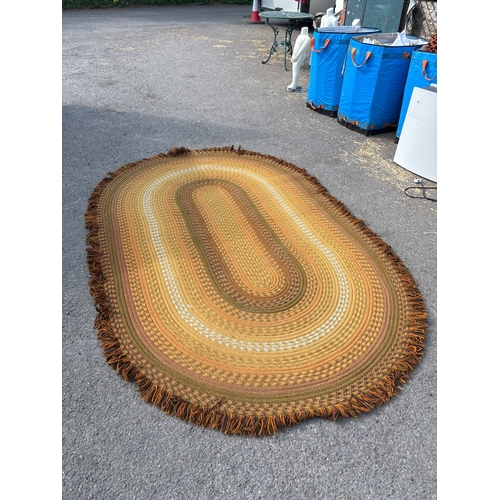 74 - 1970s oval braided rug with multicolor design, edged in fringe.not postable