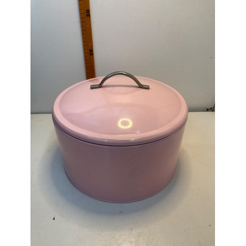 136 - Round pink cake tin with a lid and metal handle.