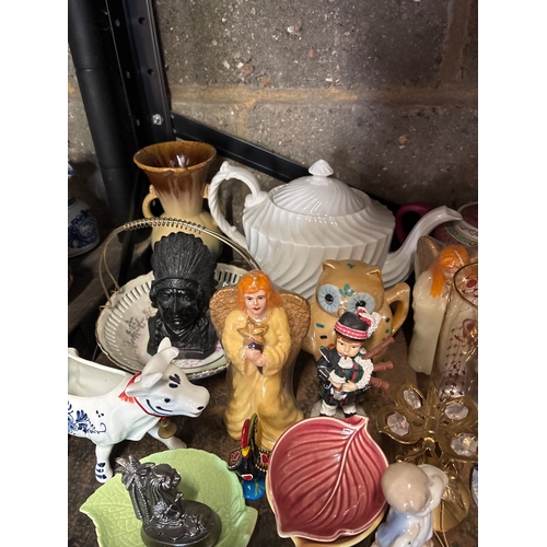 53 - Shelf containing assorted china pieces including figurines, teapots, and decorative wares. Includes ... 