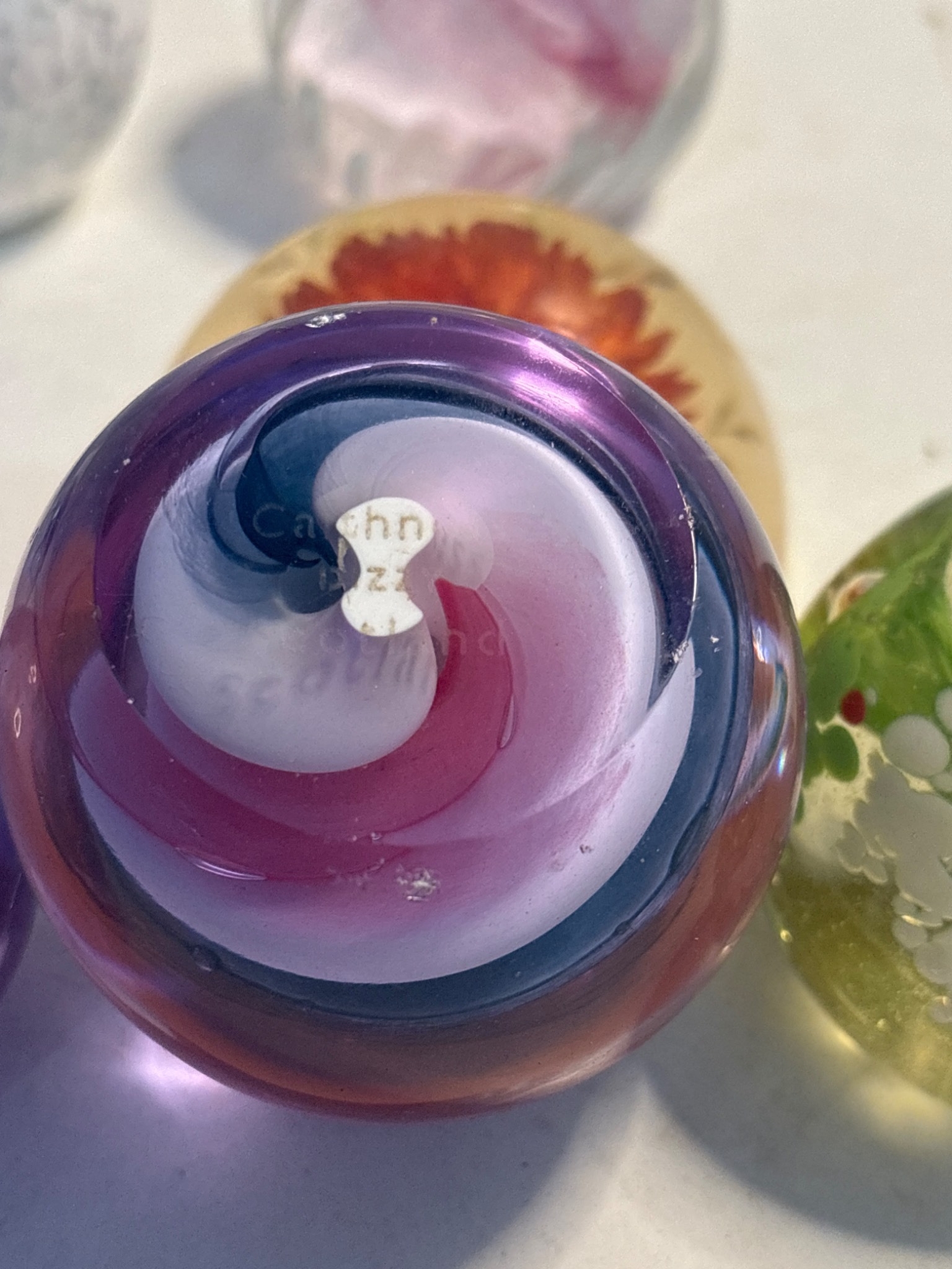 7 assorted glass paperweights featuring colorful designs and patterns ...