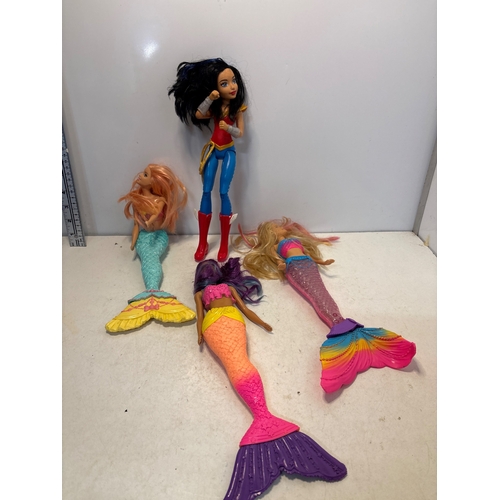 124 - Includes one superhero doll and four mermaid dolls. Various conditions and colors.