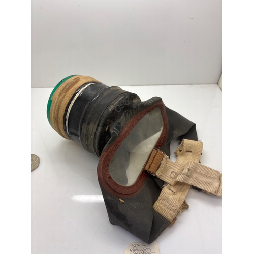 77 - Military-style gas mask with straps and glass lens.