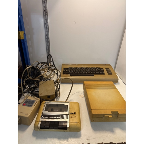 Commodore 64 computer, cassette drive, floppy disk drive, and cables.