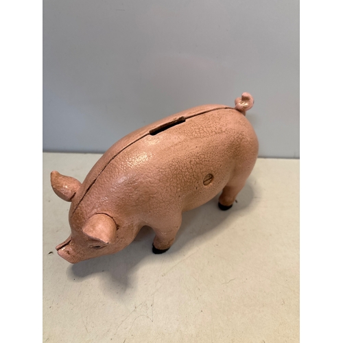90 - Cast iron pig-shaped coin bank with pink paint and coin slot.
