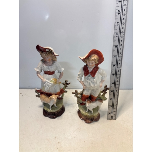 24 - Porcelain figurines depicting a boy and girl with hats and a lamb, measuring approximately 7 inches ... 