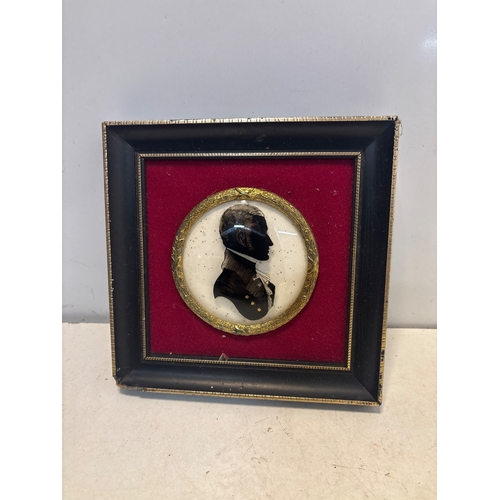 26 - Framed silhouette portrait featuring a black and gold profile on a red background with gilded accent... 