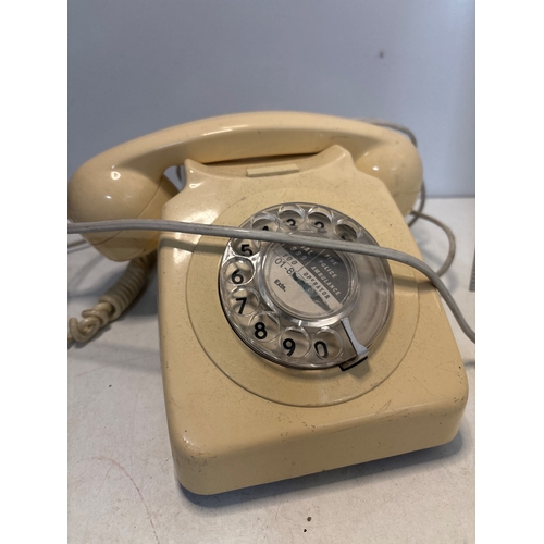 31 - Cream-colored rotary dial phone with coiled cord.