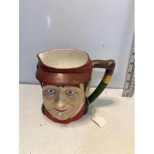 4 - Hand-painted ceramic Toby jug featuring a smiling man with a red cap and green jacket. Measures appr... 