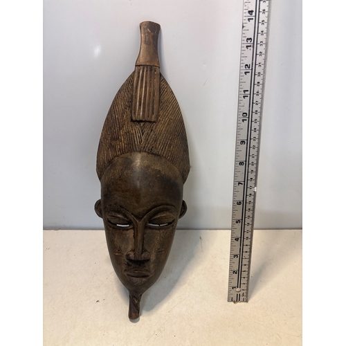 42 - Hand-carved African wooden mask, featuring intricate details and a hair comb design. Hollow interior... 